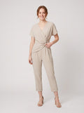 Lyra draped knot jumpsuit in beige, wrap V-neck with knotted waist, on model